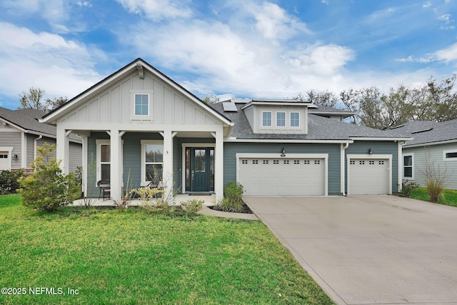 view of front of house featuring a porch, board and batten siding, a front yard, and roof mounted solar panels