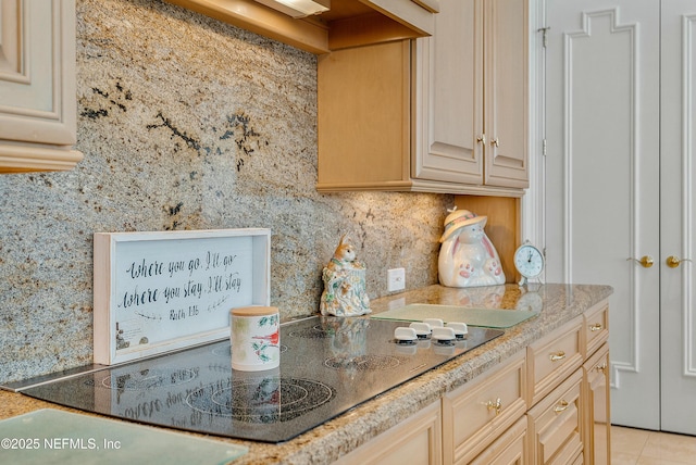 kitchen featuring black electric stovetop, decorative backsplash, light tile patterned floors, and light brown cabinets