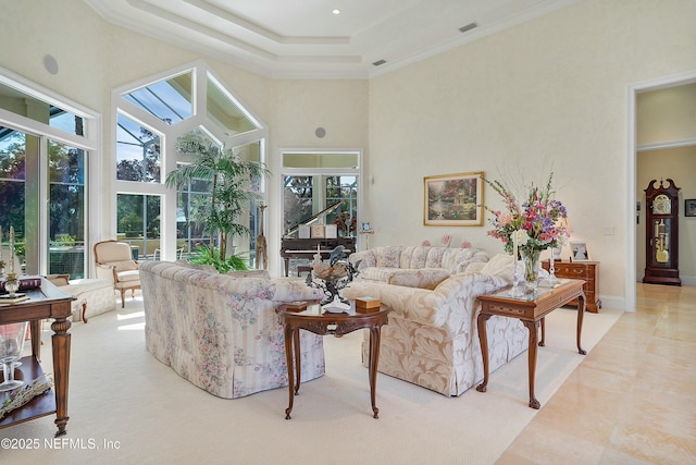 living room with crown molding, a healthy amount of sunlight, and a high ceiling