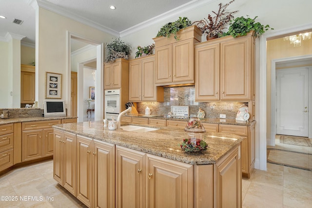 kitchen featuring light brown cabinetry and a kitchen island with sink