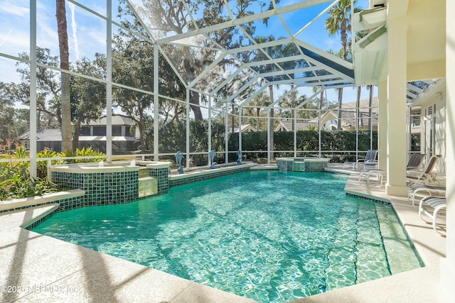 view of pool featuring an in ground hot tub, a patio, and glass enclosure