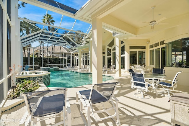 view of swimming pool featuring ceiling fan, a patio, glass enclosure, and an in ground hot tub