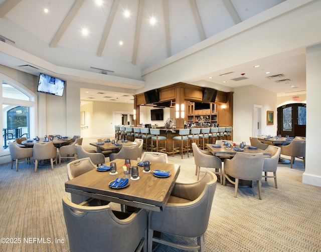 dining room featuring high vaulted ceiling, recessed lighting, light carpet, visible vents, and beam ceiling