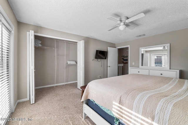 carpeted bedroom with ceiling fan, a textured ceiling, and a closet