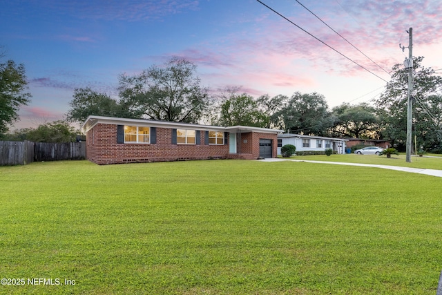 single story home with a garage and a lawn