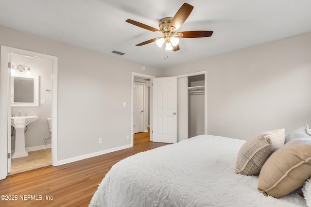 bedroom with ensuite bath, wood-type flooring, a closet, and ceiling fan