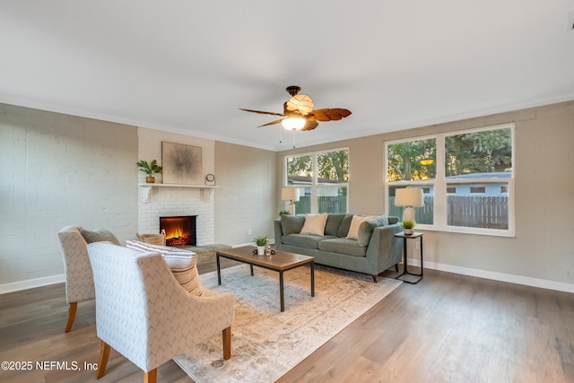 living room with crown molding, hardwood / wood-style flooring, and brick wall