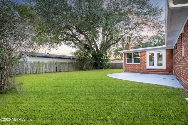 yard at dusk featuring a patio area