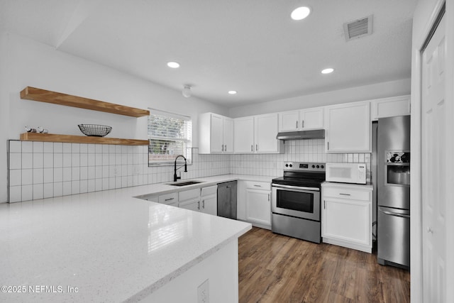 kitchen featuring sink, white cabinetry, backsplash, stainless steel appliances, and dark hardwood / wood-style flooring