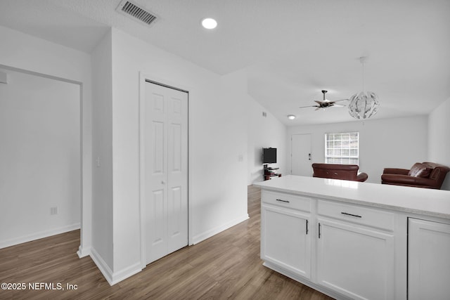 kitchen with white cabinetry, light hardwood / wood-style floors, and ceiling fan