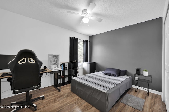 bedroom with wood-type flooring, ceiling fan, and a textured ceiling