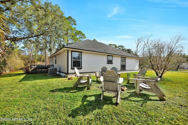 rear view of property with a wooden deck, a lawn, and central air condition unit