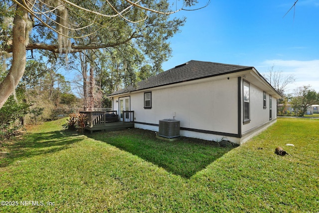 view of property exterior featuring a wooden deck, central AC, and a lawn