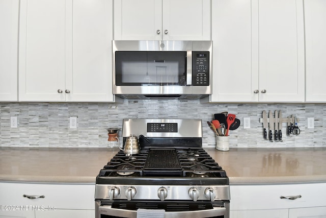 kitchen with stainless steel appliances, light countertops, and white cabinets