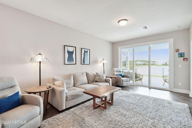 living room featuring baseboards, visible vents, and wood finished floors