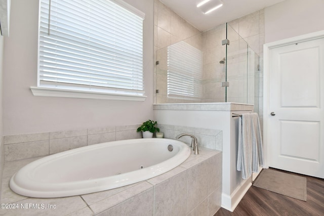 full bathroom featuring wood finished floors, a shower stall, and a bath