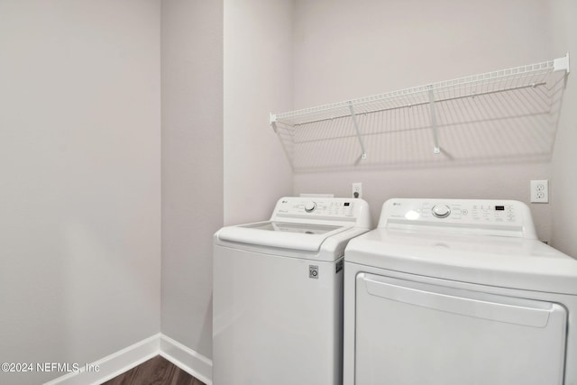 washroom featuring dark wood-style floors, laundry area, independent washer and dryer, and baseboards