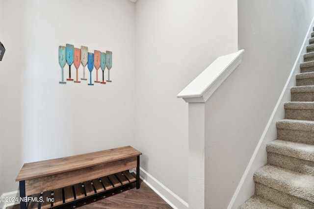 staircase featuring baseboards and wood finished floors