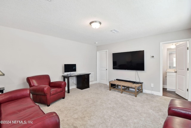 living room with a textured ceiling, carpet floors, visible vents, and baseboards