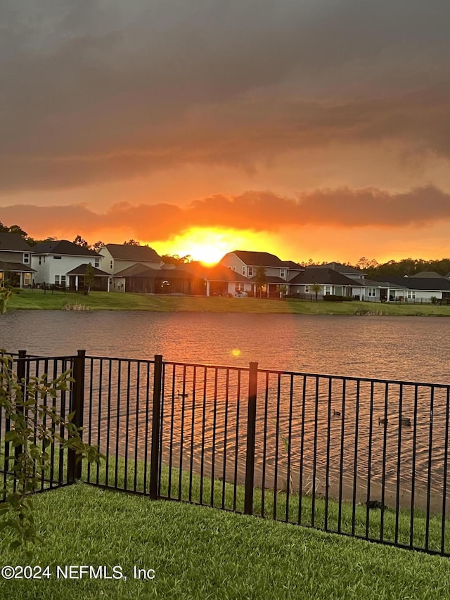 property view of water featuring fence and a residential view