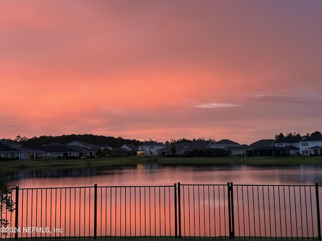 property view of water featuring a residential view and fence