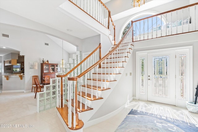 entrance foyer featuring tile patterned flooring and a towering ceiling