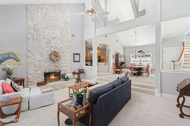 carpeted living room featuring ceiling fan, high vaulted ceiling, and a fireplace