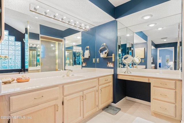 bathroom featuring vanity, tile patterned floors, a textured ceiling, and walk in shower