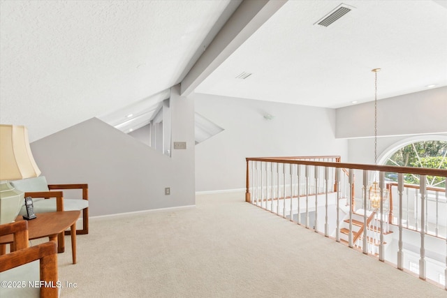 corridor featuring light carpet, vaulted ceiling with beams, and a textured ceiling