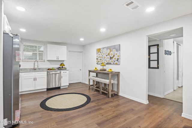 kitchen featuring white cabinetry, visible vents, stainless steel appliances, and dark wood-type flooring