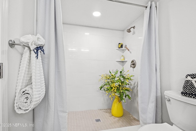 full bathroom featuring toilet and a tile shower