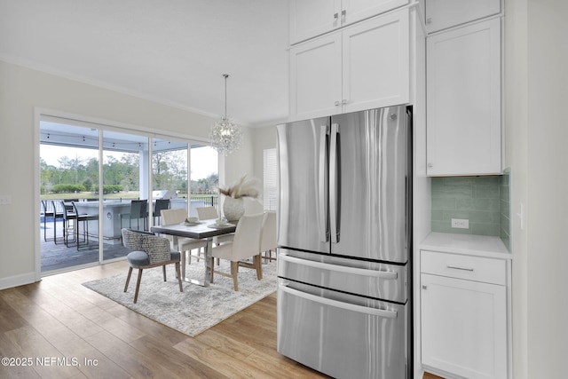 kitchen featuring tasteful backsplash, white cabinets, and stainless steel refrigerator