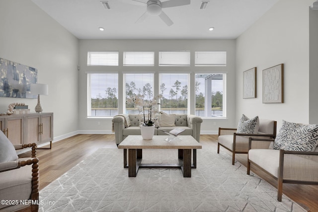 living room featuring ceiling fan, a healthy amount of sunlight, and light wood-type flooring