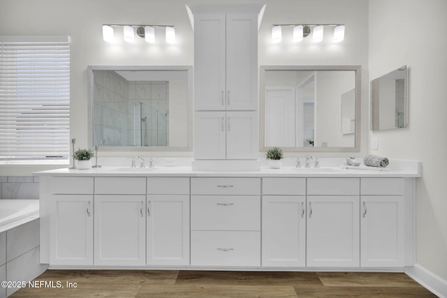 bathroom featuring hardwood / wood-style flooring, shower with separate bathtub, and vanity