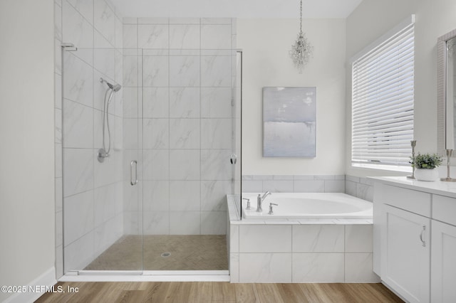 bathroom featuring wood-type flooring, independent shower and bath, and vanity