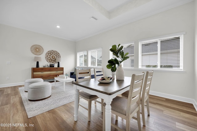 dining area with crown molding and light hardwood / wood-style flooring