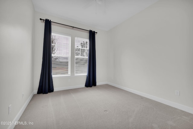 spare room featuring light colored carpet and ceiling fan