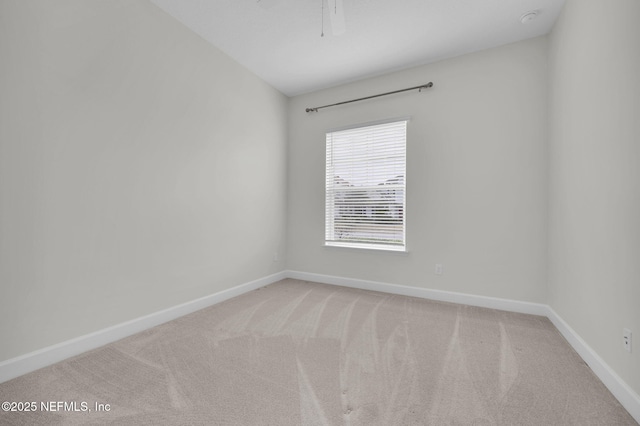 empty room featuring light colored carpet and ceiling fan