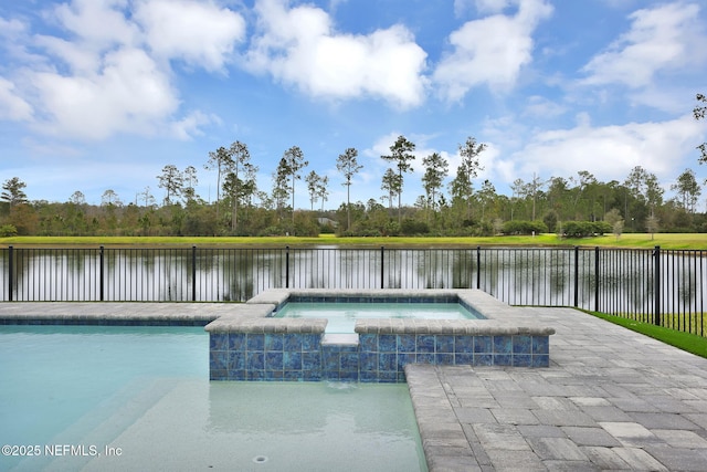 view of pool featuring an in ground hot tub, a water view, and a patio area