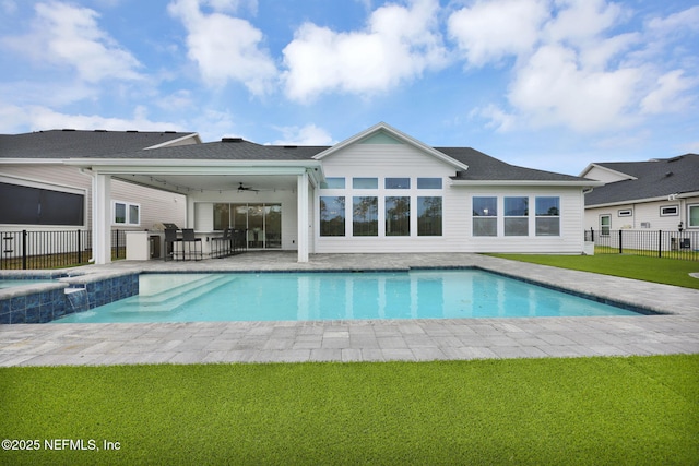 view of swimming pool with a patio, ceiling fan, and a lawn