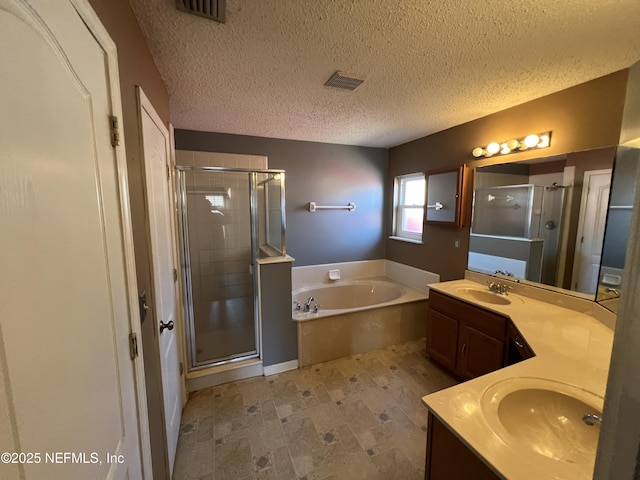 bathroom with shower with separate bathtub, vanity, and a textured ceiling