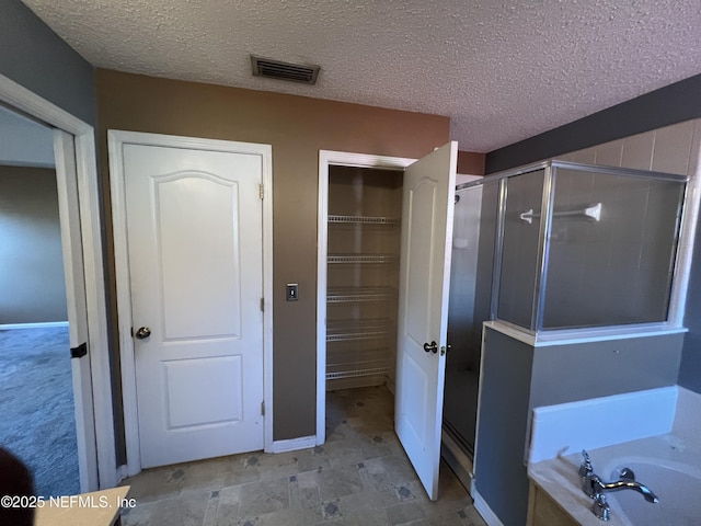 bathroom with independent shower and bath and a textured ceiling