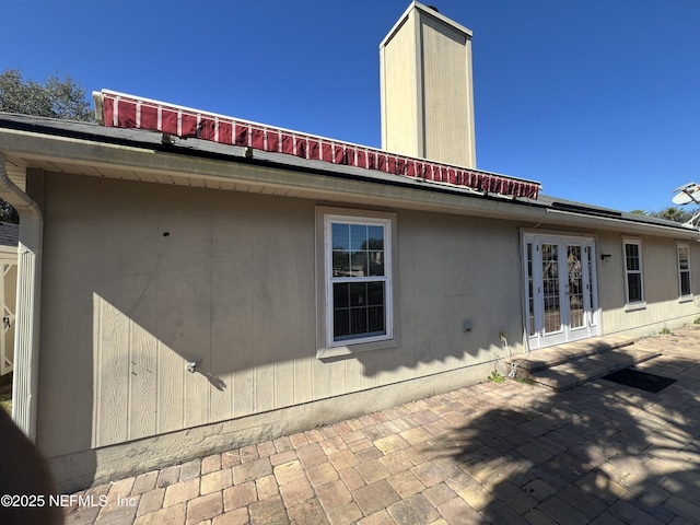 view of property exterior featuring french doors and a patio area