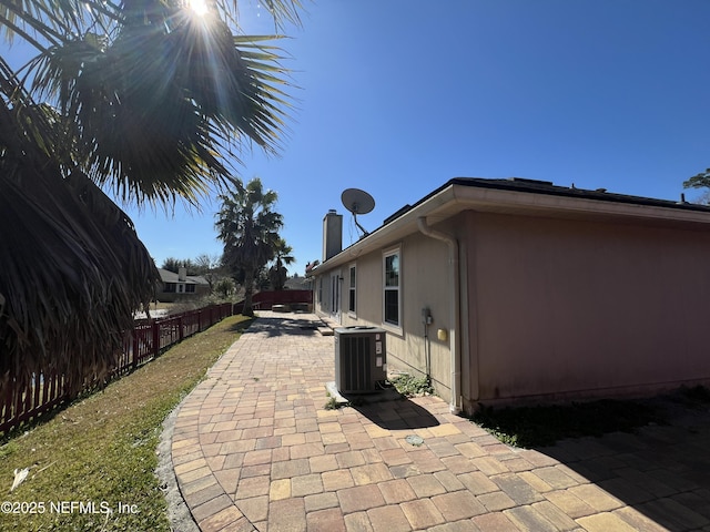 view of side of home with cooling unit and a patio