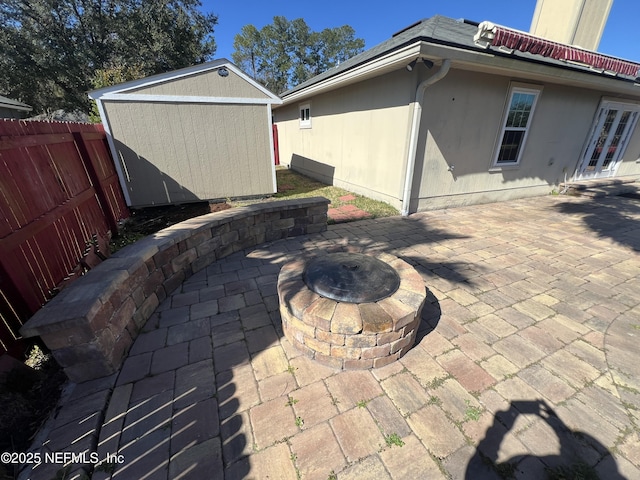 view of patio / terrace featuring a shed and a fire pit