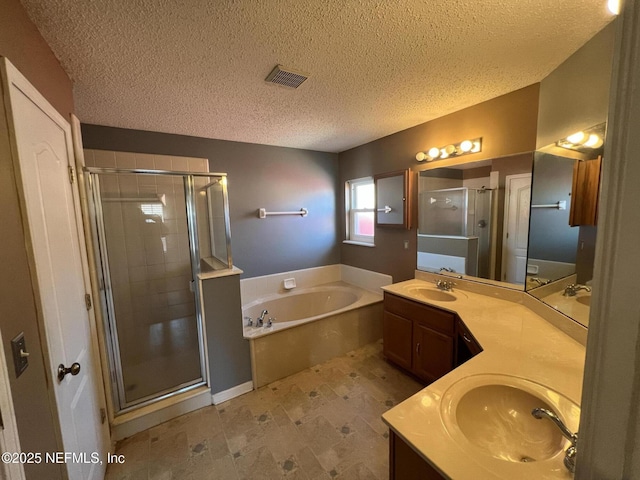 bathroom with shower with separate bathtub, vanity, and a textured ceiling