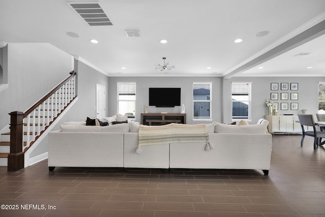 living room with crown molding and an inviting chandelier