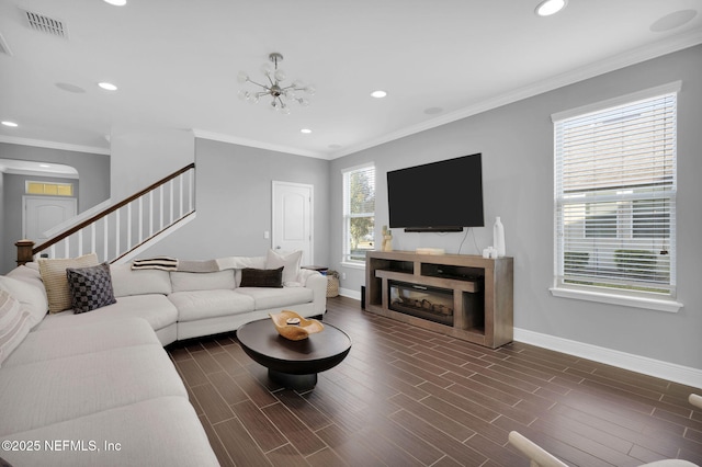 living room featuring crown molding and a notable chandelier