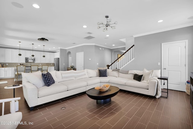 living room with an inviting chandelier and ornamental molding