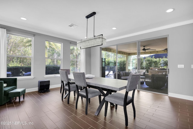 dining space with crown molding, a wealth of natural light, and dark hardwood / wood-style flooring